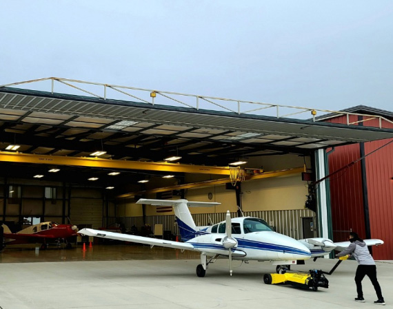 Aircraft being moved at the Qmulus hangar door